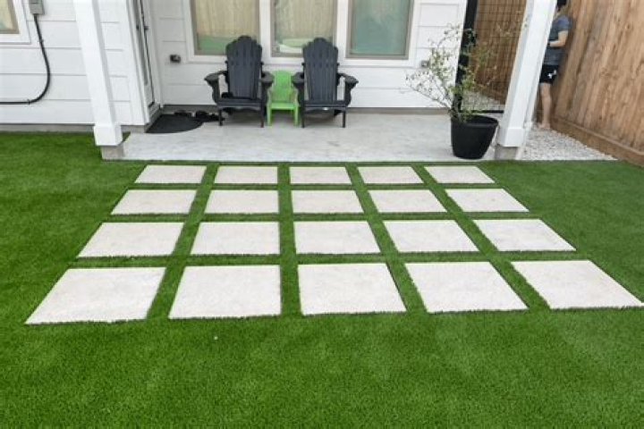 How is artificial grass held in place?
